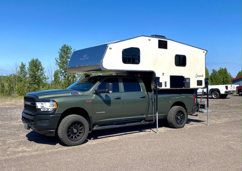 A Kingstar camper attached to a green truck.