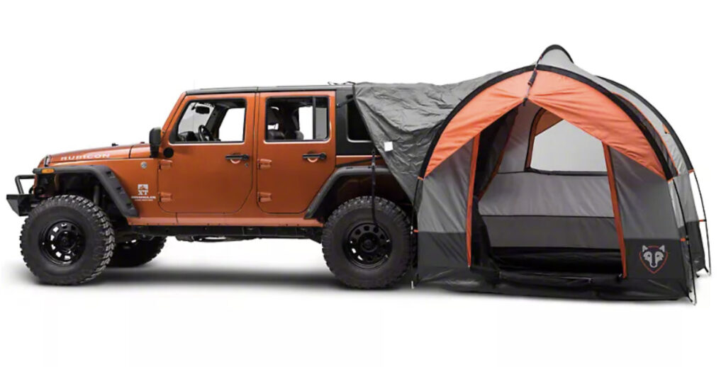A jeep camper setup on the back end of an orange jeep 