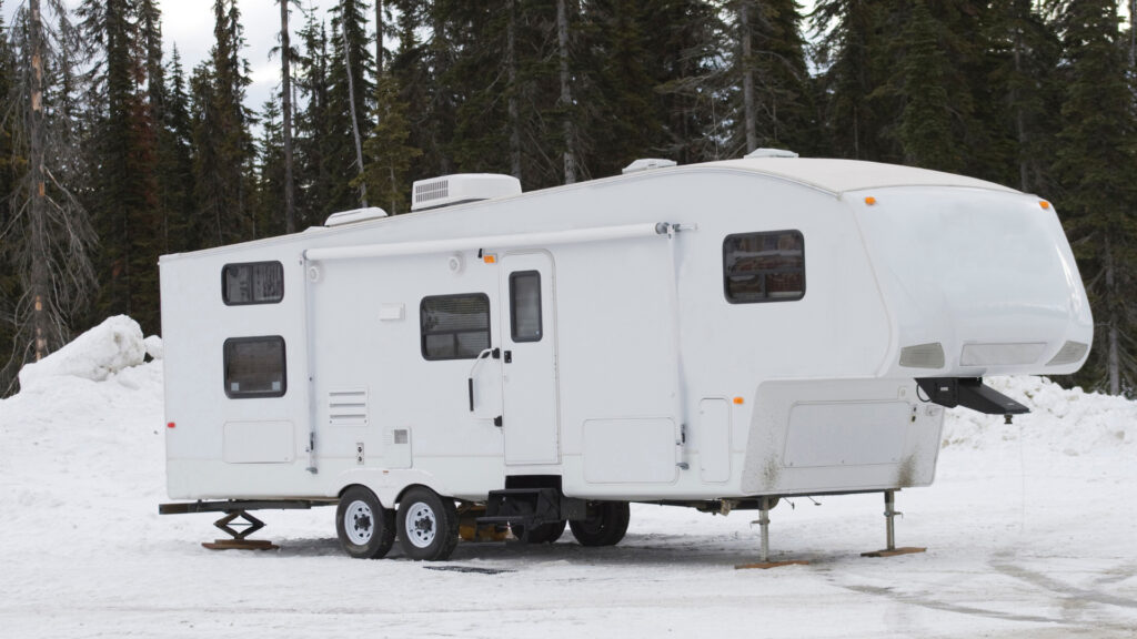A fifth wheel winterized with RV antifreeze parked in the snow