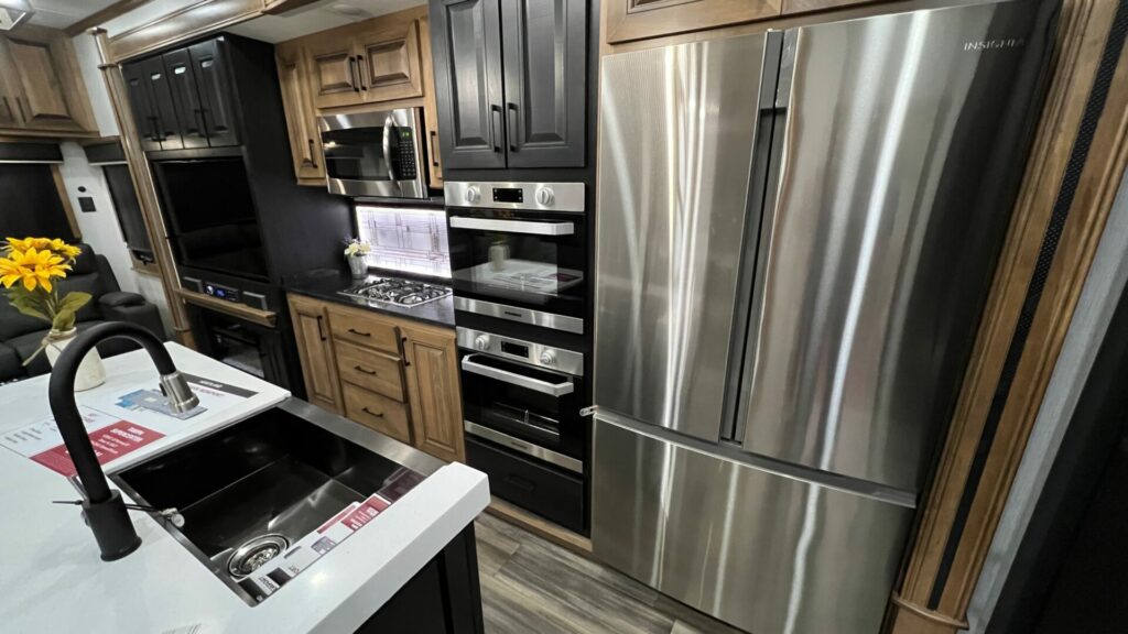 interior picture of a Heartland RV fifth wheel kitchen with a residential fridge and two ovens