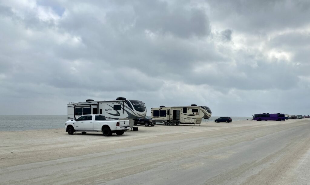 RVs boondocking on the beach with cloudy skies