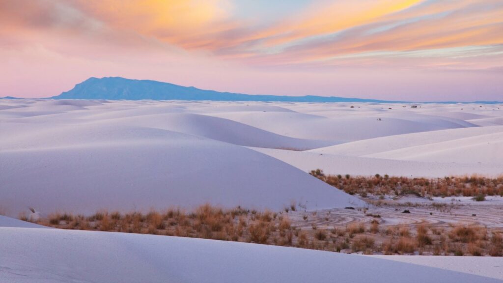 The white sand dunes during sunset with a pink sky 