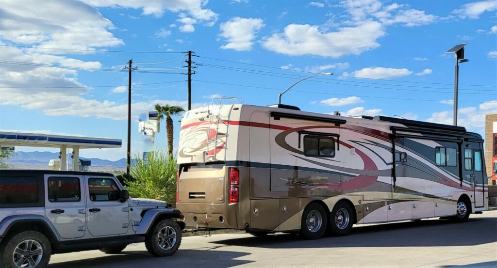 A car using an equalizer hitch to tow their motorhome.
