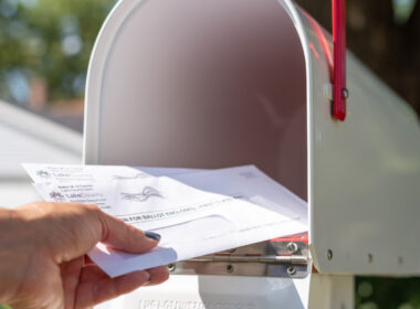 A person putting mail in a mailbox, with Americas Mailbox RVers have the option to use a USPS service for mail.