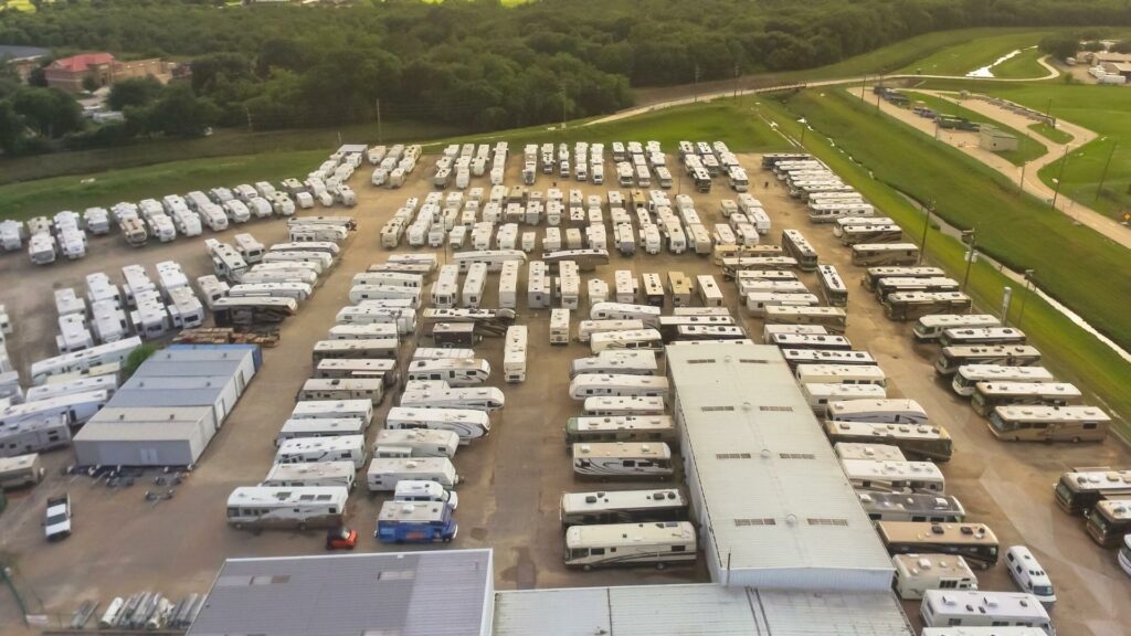 An aerial shot of tons of RVs parked in a dirt field around Gander RV
