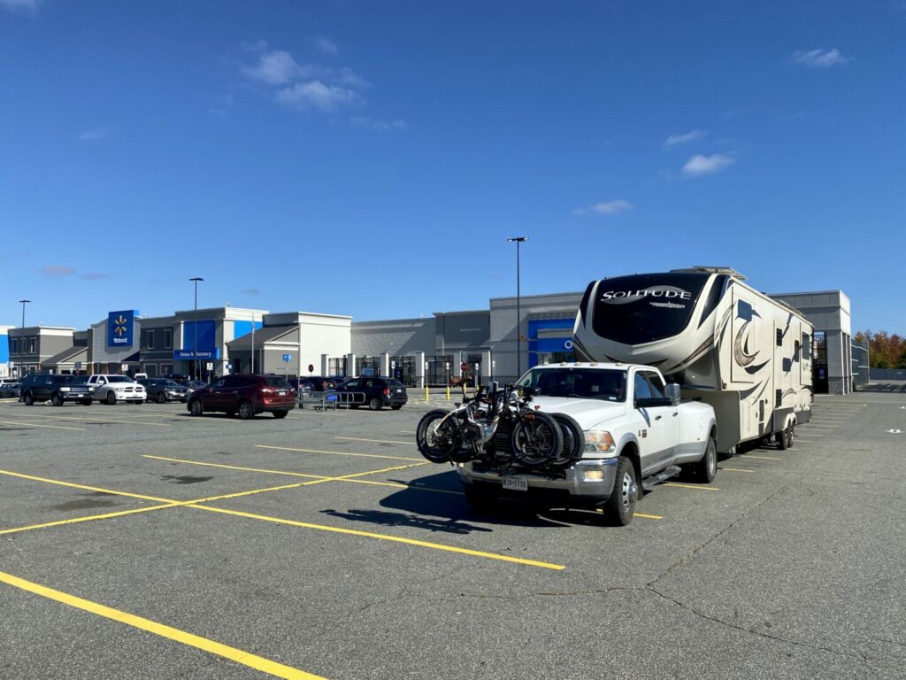 A truck towing a fifth wheel parked in a Walmart parking lot 