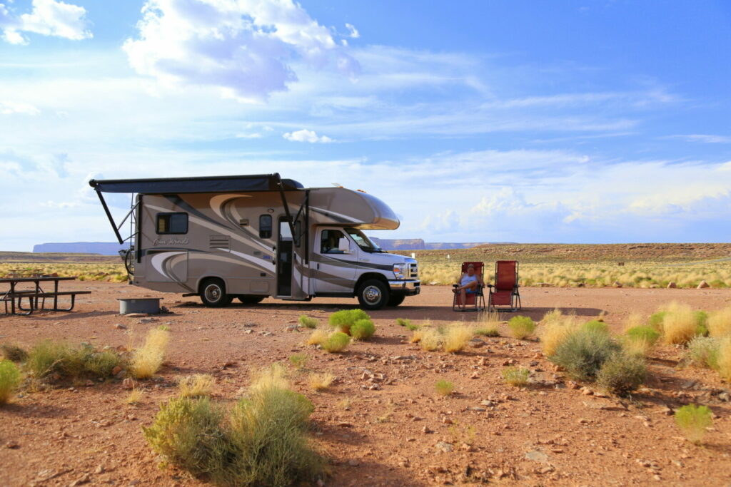 A woman outside her RV dry camping site.