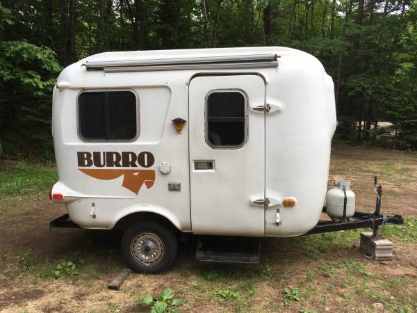 Small burro camper parked in a field