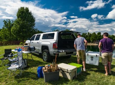 Two men lift cooler out of a truck camper shell