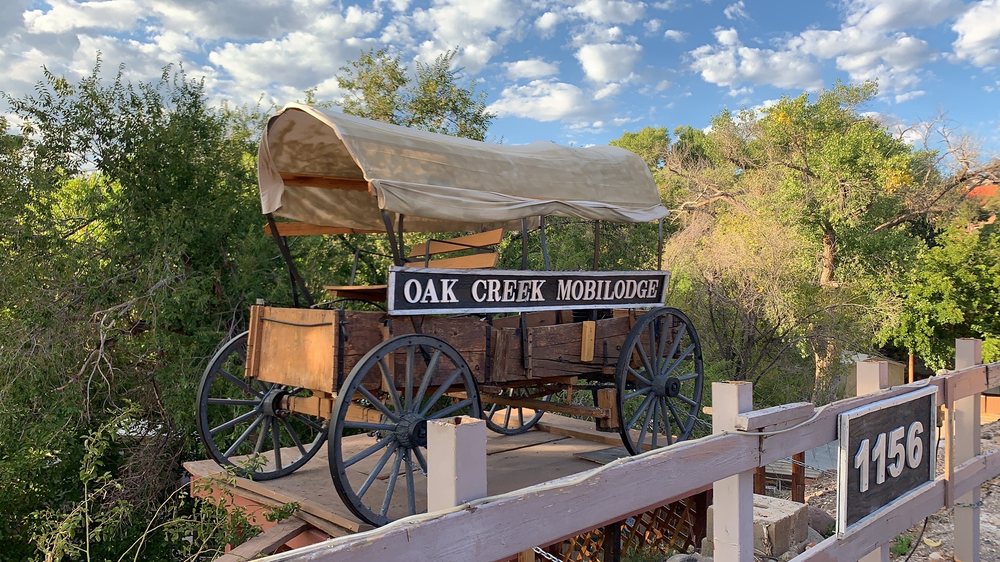 Entrance sign for Oak Creek Mobilodge on an old covered wagon