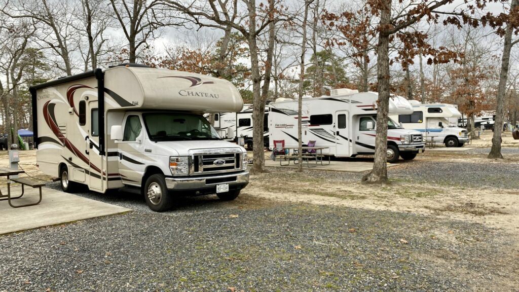 A row of Class C RVs in a campground