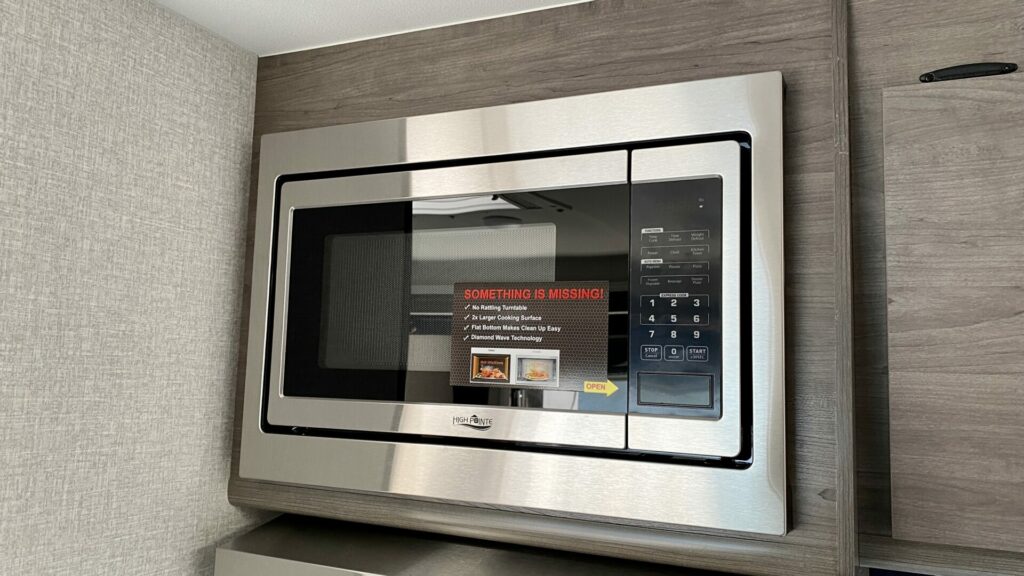An RV microwave in an RV mounted above the stove