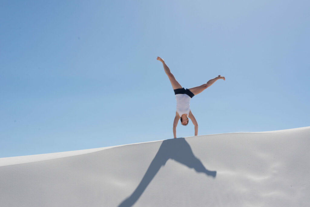 A girl cartwheeling at White Sands National Park in New Mexico