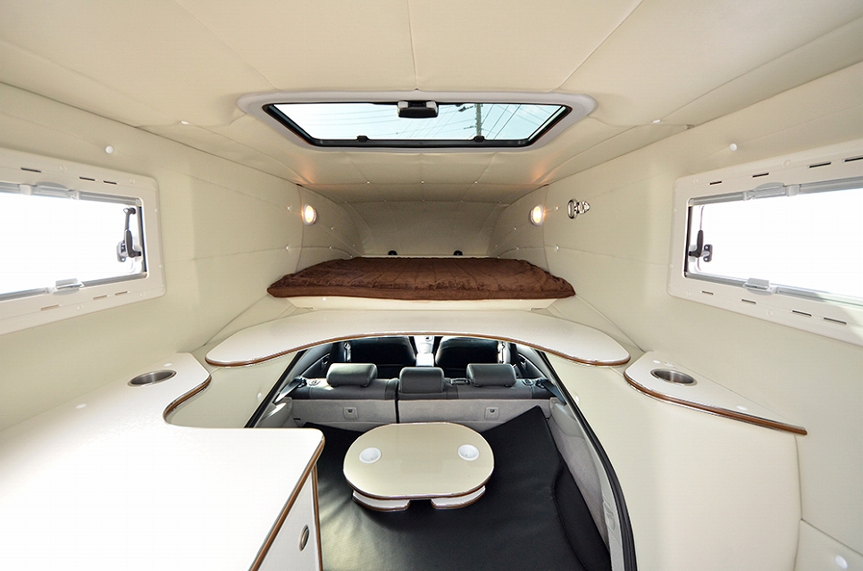 Interior picture of the Prius Camper showing the sleeping area, eating area, and windows