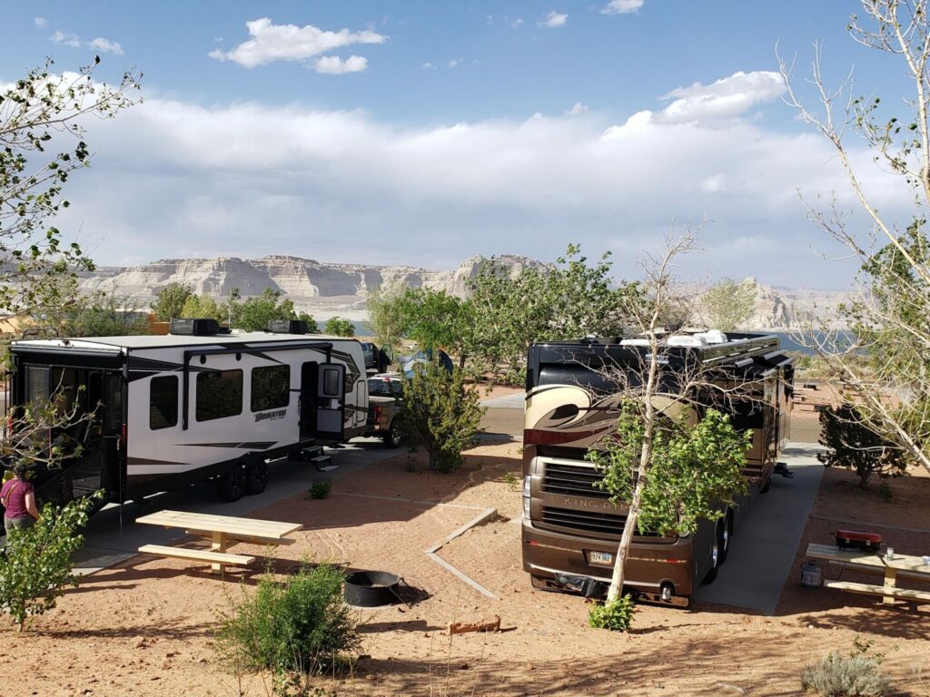 RVs parked in paved sites overlooking the lake at Wahweap RV & Campground. This is a great option for a trip when looking for campgrounds with lakes. 