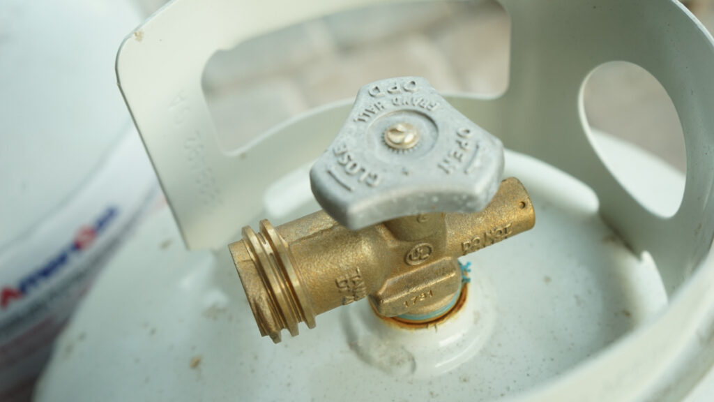 The top of a 20lb propane tank showing the connection valve.