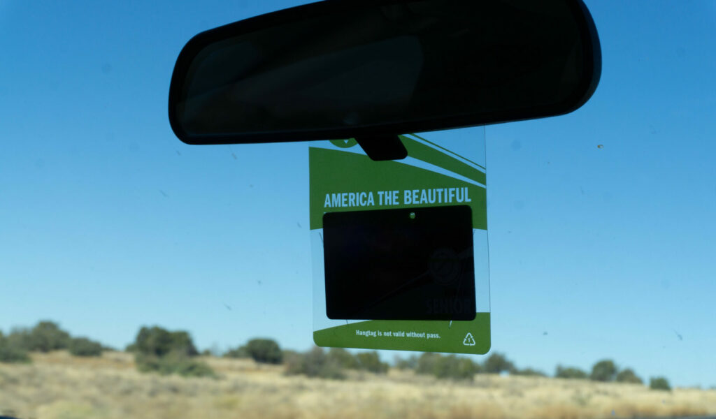 A national parks pass on a car mirror.