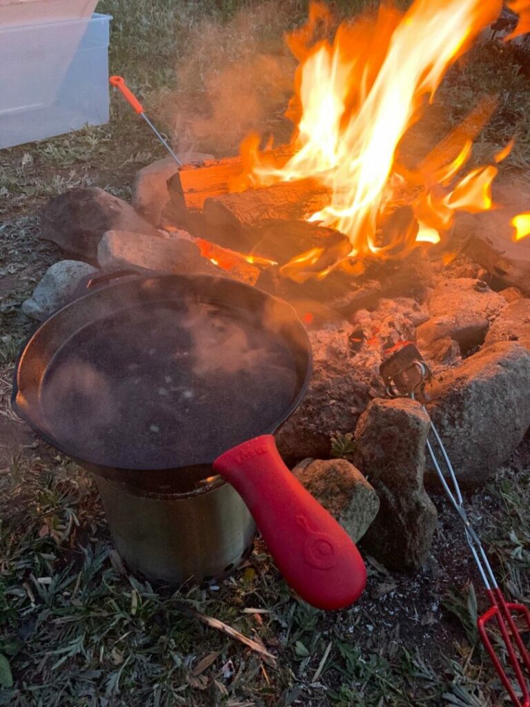Lodge cast iron cookware being used on a campfire