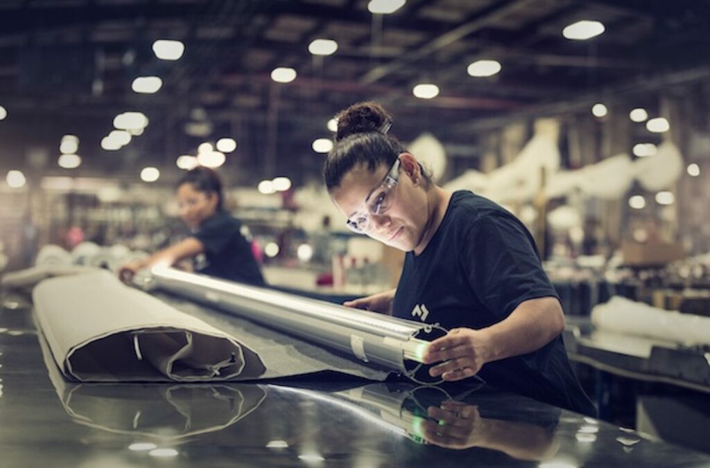A woman working in a Dometic factory making an awning light turn on 