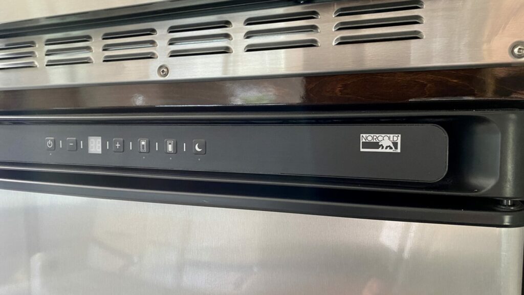 The front of a fridge that shows the brand is Norcold and it runs off battery 