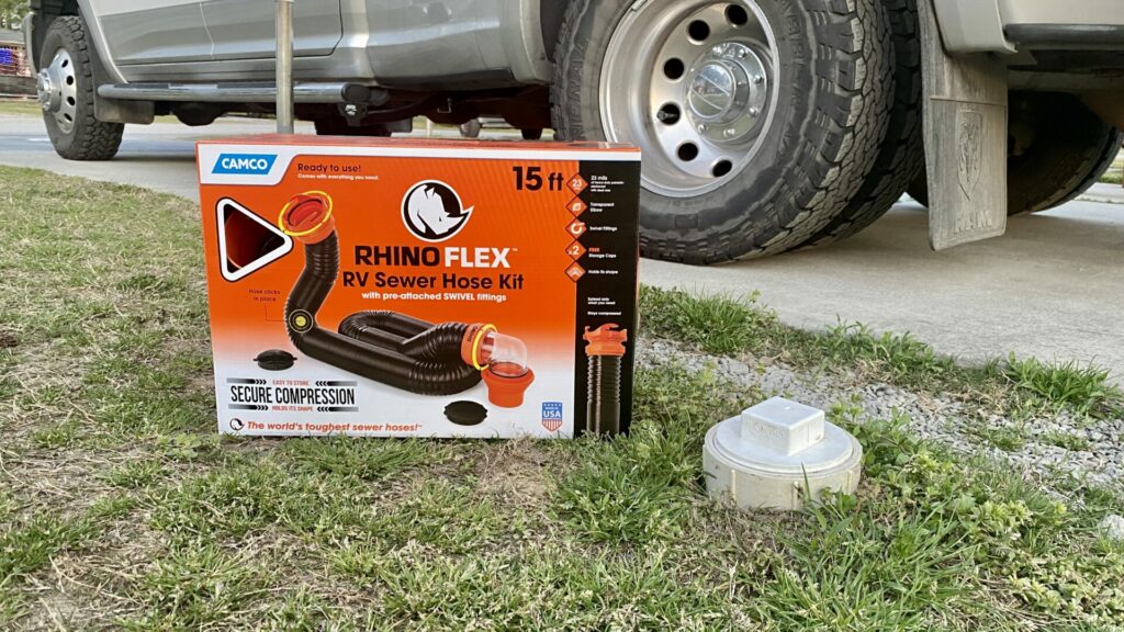 The Camco Rhino Flex Sewer Hose Kit next to a sewer outlet at a campground