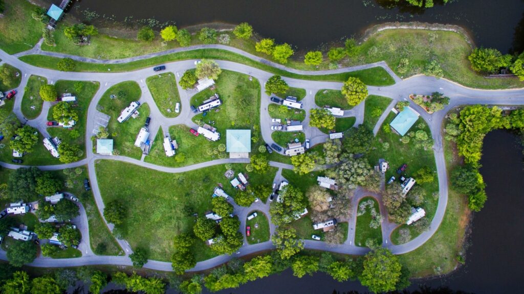 A drone shot of a campground with a body of water surrounding it and full of RVs