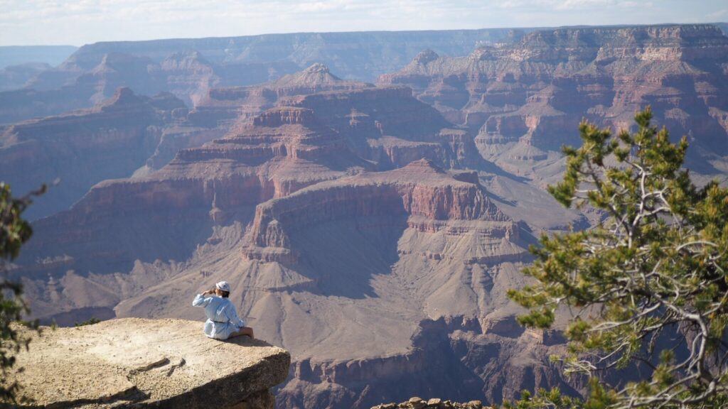Person sitting on the edge of Grand Canyon National Park, avoiding the crowds during off-season