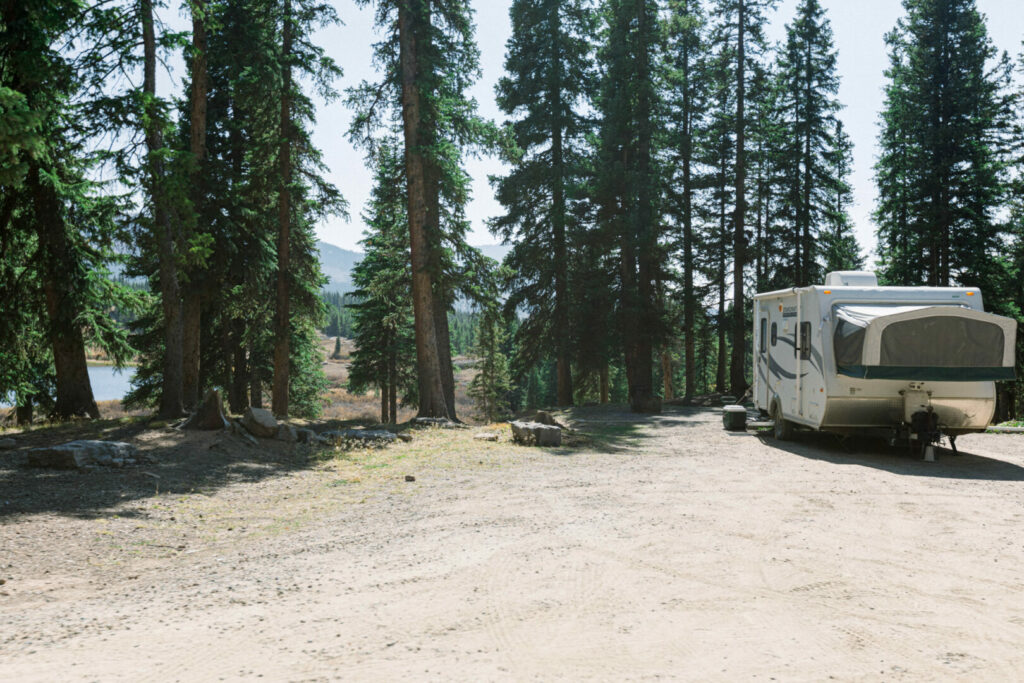 A camper parked in the shade to avoid the heat while the RV AC is being repaired