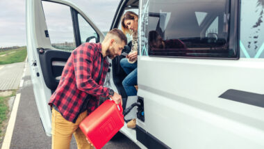 Person filling up their RV with diesel gas station to have full mileage