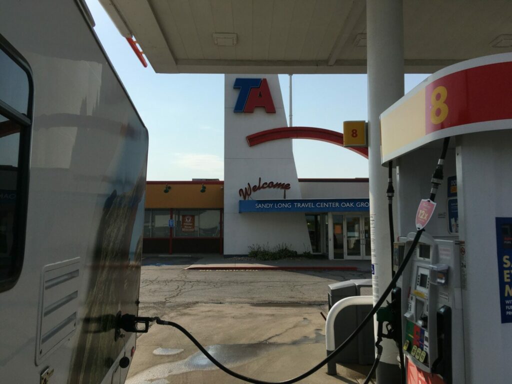An RV at a gas station filling up their mileage
