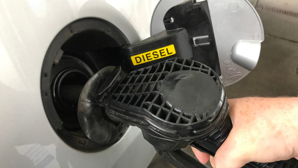 Person filling up their RV with diesel  gas station to have full mileage