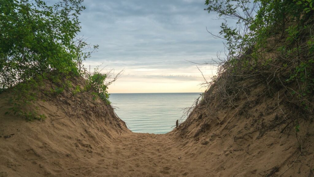 A walkway over a sand dune showing Lake Michigan in the background 