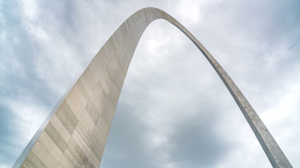 A picture of the Gateway Arch from underneath with blue sky above
