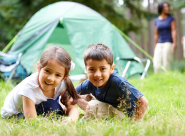 Siblings outside their tent preparing for fun camping activities