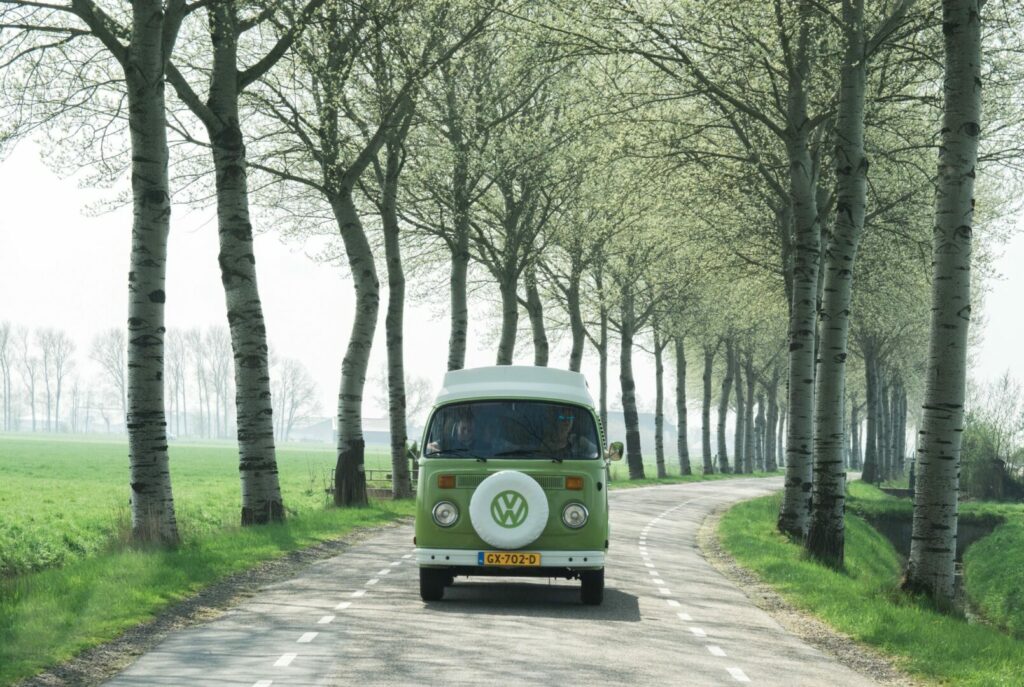 A vintage camper driving on a road