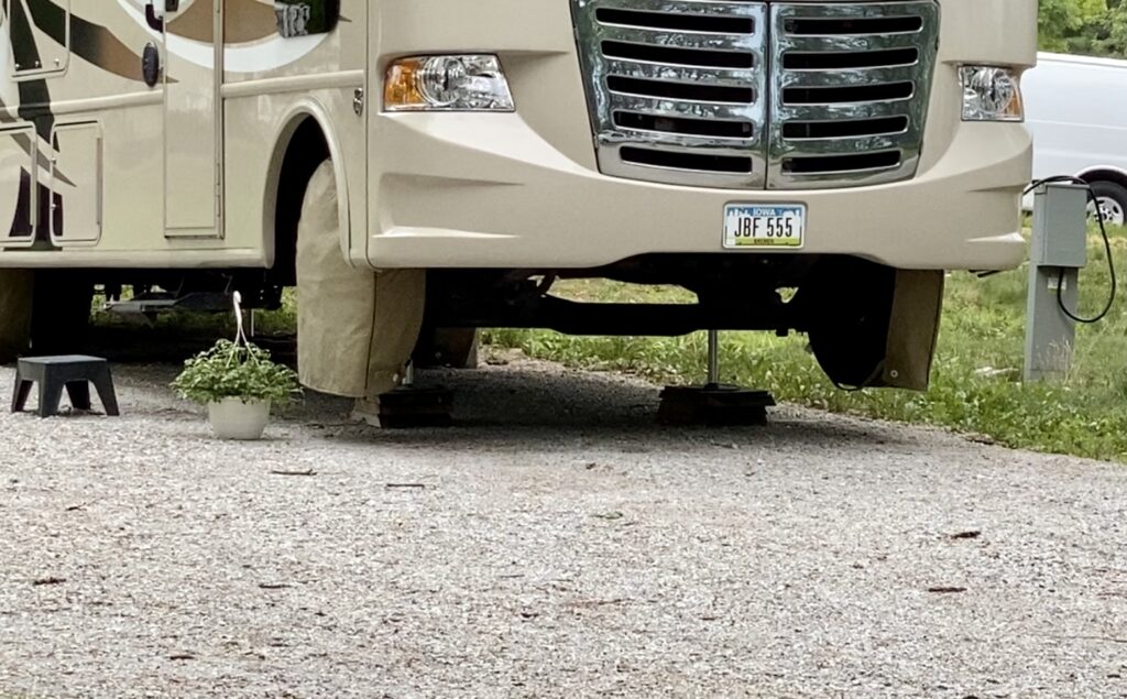 An RV using its stabilizers with the front tires off the ground 