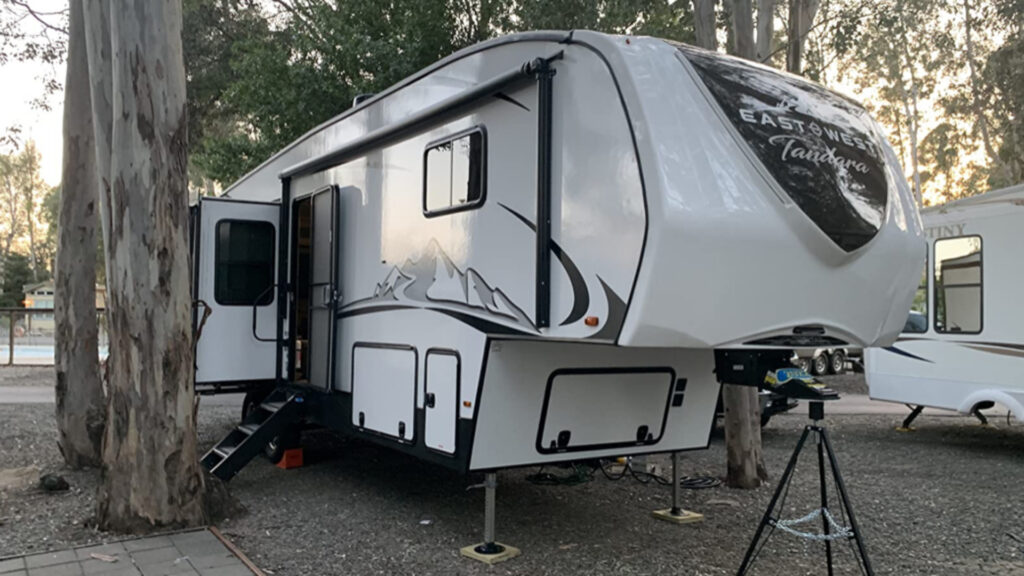 A fifth wheel parked in an RV park using a 5th wheel tripod stabilizer