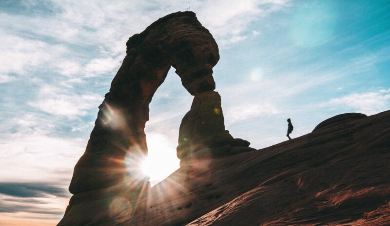 A person walking at Arches National park, during the best time to visit Utah