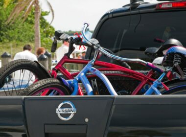 A truck on the road with bikes in the truck bed bike rack