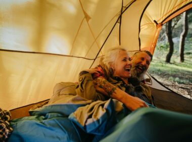 A couple laughing at camper van jokes in their tent