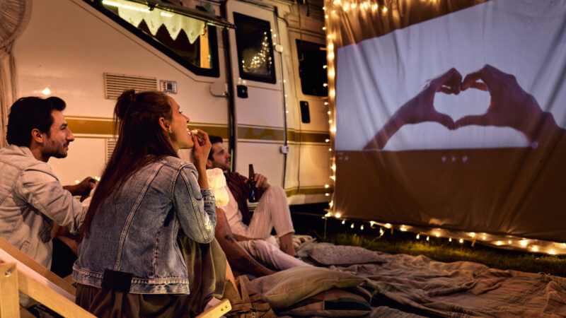 A group of campers watching a movies about camping outside their rv