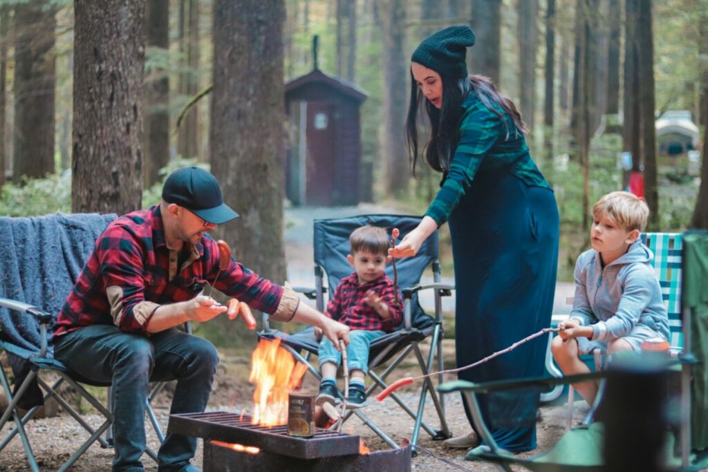 A family by the campfire after reading up on how to get campfire smell out of clothes before lighting a fire