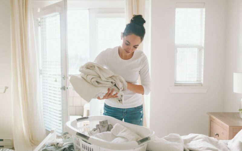 A woman putting away her clean laundry after following ways on how to get diesel smell out of clothes