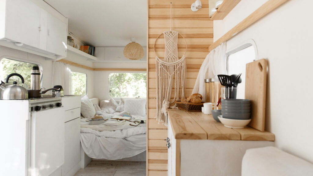 An RV bedroom and kitchen with furniture 