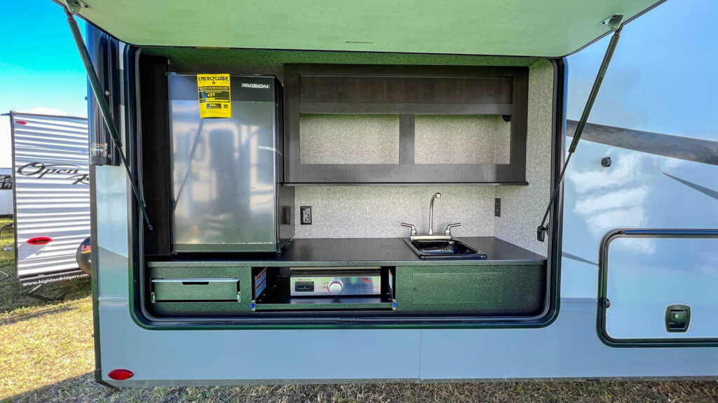 Exterior RV door open showing an outside RV kitchen