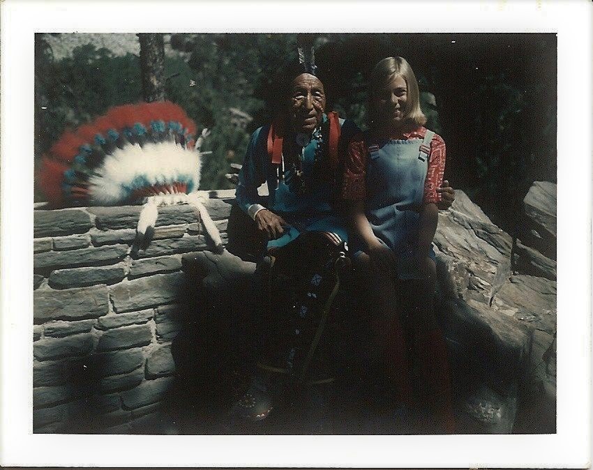 Old colored photograph of Ben Black Elk and a park visitor at Mount Rushmore