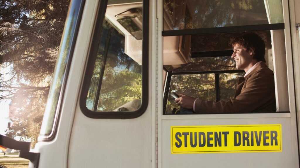 A guy driving a Class A RV with a yellow student driver sign on the side 