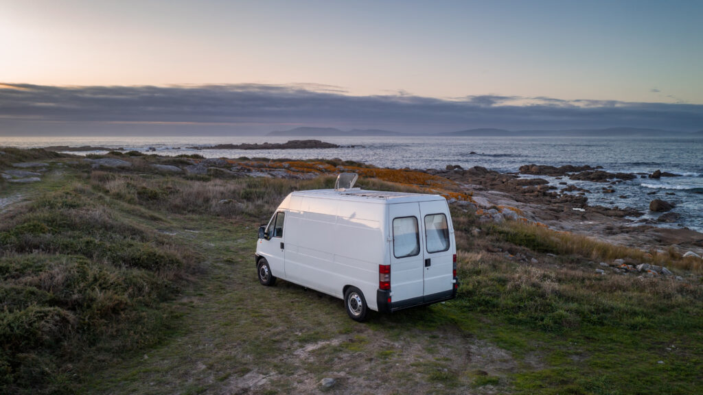 A van parked at the beach that was converted using one of the best van conversion companies