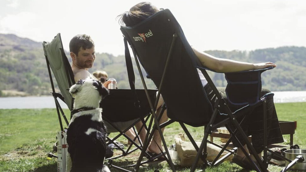A couple and their dog sitting in their sunnyfeel luxury padded rocking camp chair