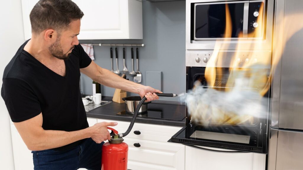 a man putting out a fire in his RV oven with a fire extinguisher 